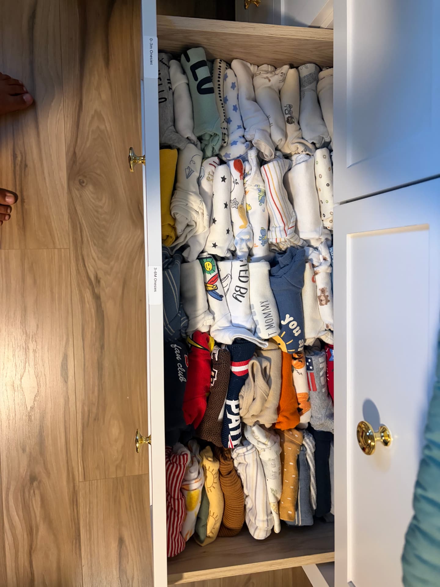 Children’s clothing sorted by size and neatly arranged in a labeled drawer