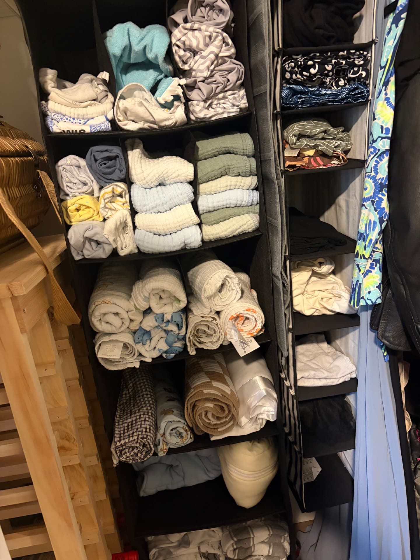 Folded linens and clothing arranged in hanging closet shelves